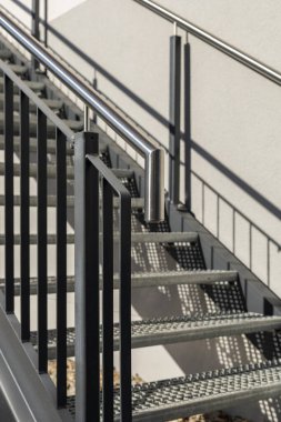Gösterişli merdivenlerde metal parmaklıklar ve modern uzaya dokunuşlar sunan basamaklar yer alıyor. Gölgeler yüzeyde dans eder, tasarım detaylarını geliştirir. Metal yapı, kaynak, çelik merdiven.
