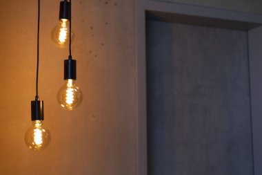 Üç şık kolye ışığı çağdaş bir ortamda sıcak bir parıltı yayar. Yumuşak aydınlatma, uzayın minimalist tasarımını vurguluyor ve rahat bir atmosfer yaratıyor..