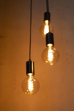 Tavandan sarkan üç kolye, rahat bir iç mekan ortamında sıcak bir parıltı bırakıyor. Ortam davetkar, toplantılar ya da sessiz akşamlar için mükemmel..