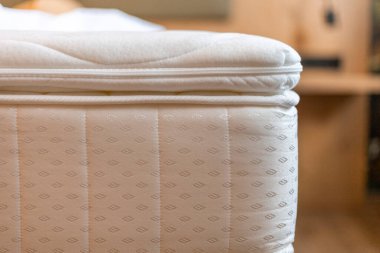 İyi işlenmiş bir yatak, örtülü kumaşı ve detaylara olan ilgisini gösteren sıcak ve davetkar bir yatak odasına güzelce yerleştirilir. Barışçıl bir atmosfer rahatlamayı teşvik eder..