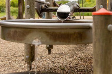 Çocuklar, suyun bir kanaldan havzaya aktığı ve doğayla etkileşimli bir deneyim sağladığı bir oyun alanında eğlenceli ve eğitici bir aktivitenin tadını çıkarabilirler..