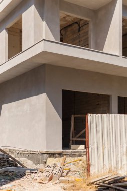 İnşaat faaliyetleri, beton yapıya, açık çerçevelere ve etrafa saçılmış inşaat malzemelerine sahip gelişmekte olan bir inşaat sahasında görülmektedir..