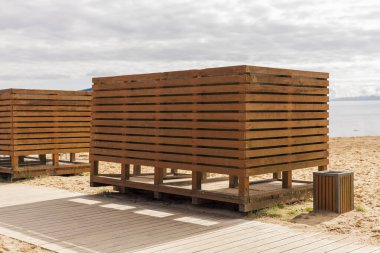 Plaj yakınlarındaki ahşap kabinler plaj ziyaretçileri için özel bir alan sunuyor. Yapılar konfor ve rahatlık için tasarlandı, plaj deneyimini geliştirmek için..