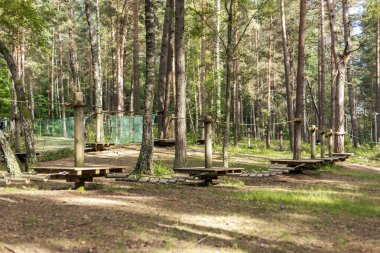 Uzun, yapraklı ağaçlarla çevrili bir ağaç parkında heyecanlı bir açık hava macerası yaşayın. Bu doğal ortam, keşif için tasarlanmış çeşitli ip köprüler ve ahşap yollar içerir..