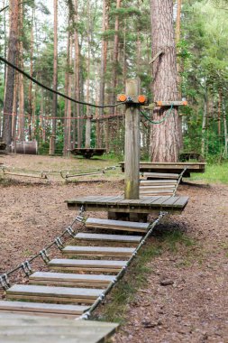Bir orman macera alanının çeşitli bölümlerini birbirine bağlayan ahşap bir yol. Halatlar ve sağlam kalaslar var..
