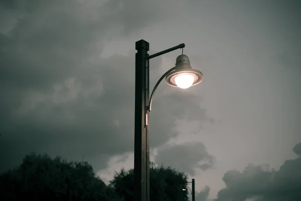 Bulutlu bir gökyüzüne karşı sokak lambası. Alacakaranlık.