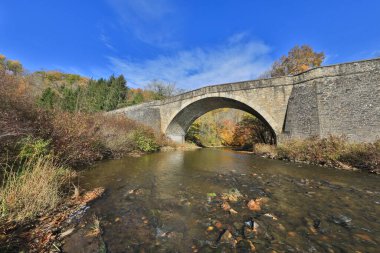 Garrett County Maryland 'deki Casselman Nehri Köprüsü' nü çevreleyen güzel sonbahar rengi
