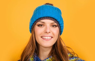 Sıcak örgü şapkalı ve atkılı gülümseyen kadın. Kış kıyafetleri.