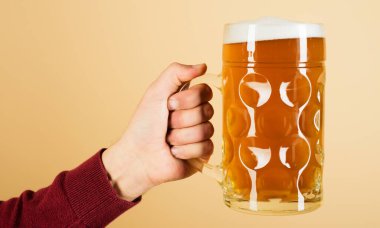 Elinde bira bardağı olan bir erkek eli. Oktoberfest içeceği. Alkol, parti, degulasyon ve tatil kavramı