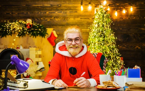 Счастливый Бородатый Санта Клаус Пишет Списке Желаний Сидя Дома Рабочим — стоковое фото