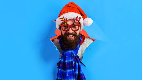 Bearded man in party glasses, Santa Claus hat and scarf. New year party. Christmas sales. Discount