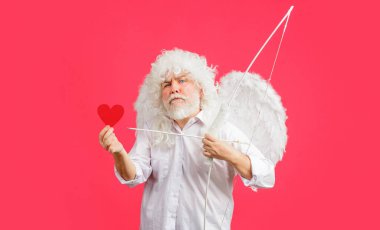 Valentines Day. Angel in white wings with bow and arrow hold red paper heart. Valentine cupid. Love