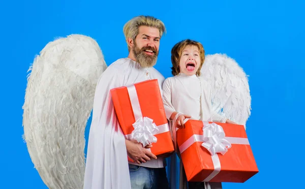 Valentines day. Little cupid boy and bearded man in angel wings with valentine gift. Father and son