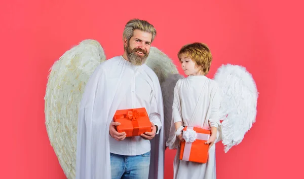 Father and son in angelic wings with Valentines gift. Cupid with Valentine present. Happy holidays