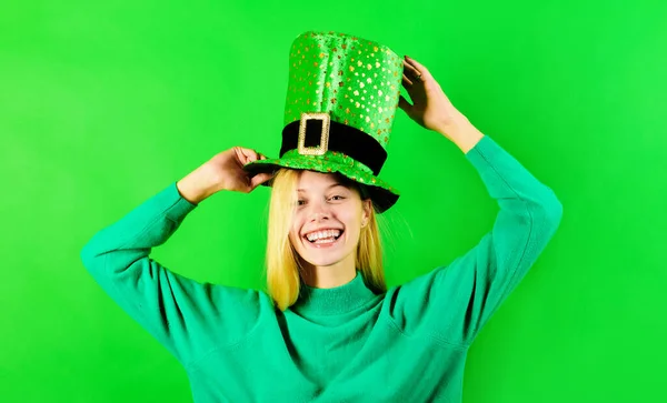 Patricks Day. Smiling blonde girl in green top hat celebrate Patricks Day. Traditions of Saint Patrick Day. Happy woman in green Leprechaun hat with clover. Irish traditions. Patrick day party