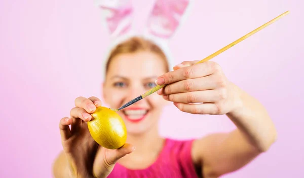ハッピーイースターお祝い イースターのために卵を描く幸せなウサギの女の子 選択的フォーカス イースターエッグの装飾のアイデア 筆と黄色の卵を持つ女性の手 イースターエッグを描く工程 — ストック写真