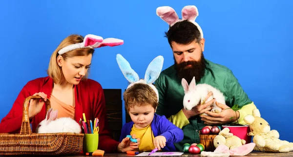 イースターの色の卵を持つ家族 お母様 お父様 お子様がイースターに備えてください 休日のために卵を描く親と子供 ウサギの耳にウサギの家族 卵狩り イースターを祝う幸せな家族 — ストック写真