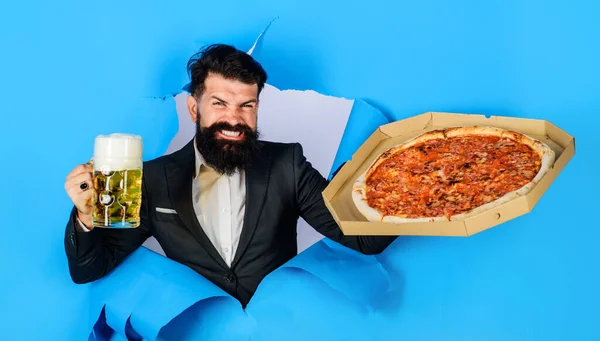 Pizza time. Happy bearded man with pizza and beer mug looking through paper. Restaurant or pizzeria. Fast food. Italian food. Businessman with pizza and mug of beer. Pizza delivery. Business lunch