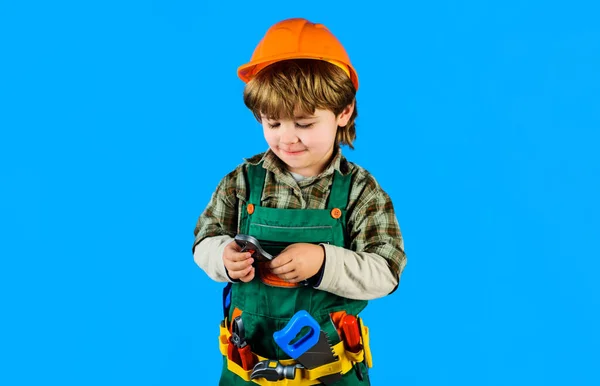 穿着安全帽和带扳手的工具带的小男孩 穿着建筑工人制服的孩子带着可调扳手 修理工具 小修理工 工匠或工头玩建筑工具 — 图库照片
