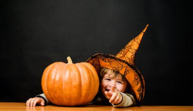 Cadı şapkalı, elinde fenerle gülümseyen bir çocuk. Mutlu Cadılar Bayramı Partisi. Büyük balkabaklı küçük çocuk. Cadılar Bayramı 'nda sihirli balkabağı olan çocuk. Cadılar Bayramı için hazırlık. Şeker mi şaka mı? Sonbahar satışları
