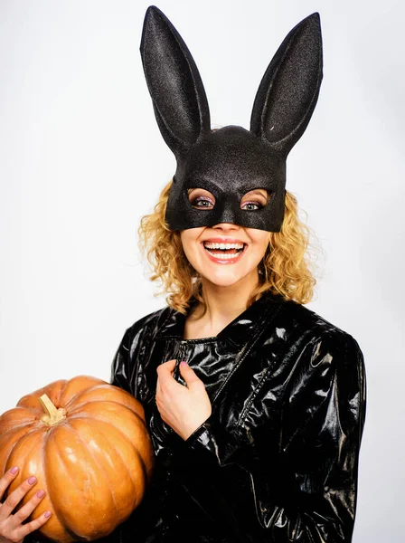 Smiling woman in Halloween bunny mask with pumpkin. Halloween party. Blonde girl in rabbit mask with Jack-o-lantern. Sexy girl in Halloween costume with Jack-o-lantern pumpkin. Autumn sale. Discount