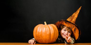 Cadılar Bayramı balkabağıyla gülümseyen cadı şapkalı çocuk. Cadılar Bayramı için hazırlık. Şükran Günü yemeği. Cadılar Bayramı çocuğu ve balkabağı. Şeker mi şaka mı? Cadılar Bayramı indirimi. İndirim