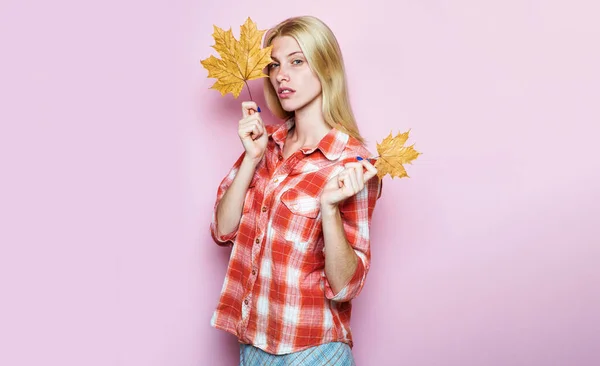 Sensual woman in plaid shirt with autumn leaf. Autumn fashion for women. Autumn girl with golden maple leaves. Blonde female model in casual wear with yellow leafs. Autumn sale. Discount. Advertising