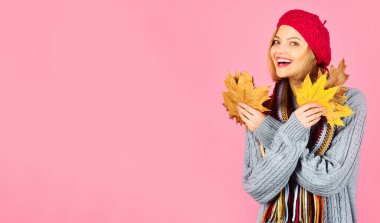 Şapkalı, eşarplı ve akçaağaç yapraklı gülümseyen kız. Sonbahar yapraklı, kalın giysiler içinde mutlu bir kadın. Kadınlar için modaya uygun sonbahar modası. Sonbahar alışverişi. Sonbahar indirimi. İndirim. Metin reklamı