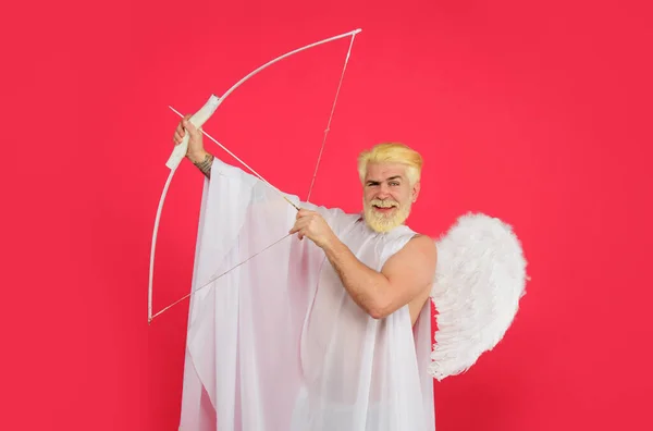 stock image Happy Valentines Day. Cupid angel with bow and arrows. Smiling bearded man in white angel wings shooting love arrow. Male angel with bow and arrow in valentines day. Valentines Day sale. Discount