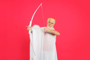 Sevgililer Günü. Sevgililer günü meleği kanatlarıyla yay ile nişan alıyor. Aşk. Aşk Tanrısı. Ok ve yayla melek kostümü giymiş gülümseyen sakallı adam. Sevgililer Günü 'nde sevgililer günü meleği aşkın okunu atıyor.