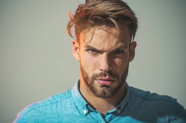 Şık saç stili kot gömlekli, modaya uygun sakallı adam. Duygular, duygular, yüz ifadeleri konsepti. Kızgın çekici bir adamın yakın plan portresi. Günlük giysiler içinde yakışıklı bir iş adamı.