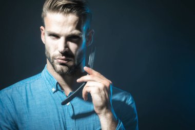 Düz jiletle şık kot gömlekli ciddi sakallı bir adam. Klasik berber dükkanı. Berber dükkanında tıraş olmak. Sakallı ve bıyıklı yakışıklı adam tıraş olmaya hazır. Berber dükkanı reklamları için yer kopyala