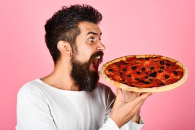 Pizza zamanı. Lezzetli pizzası olan yakışıklı sakallı adam. Öğle ya da akşam yemeği. Gündelik kıyafetlerle doymuş aç bir adam lezzetli pizzanın tadını çıkarıyor. İtalyan mutfağı. Fast food. Teslimat servisi. Pizzacı reklamı.