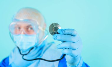 Sağlık ve ilaç servisi. Doktorların yakın çekimleri steteskoplu mavi eldiven veriyor. Seçici odaklanma. Hastane ya da klinik reklamı. Gözlüklü, cerrahi şapkalı ve maskeli steteskoplu bir erkek doktor.