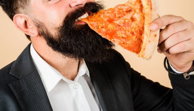 Yakından kesilmiş sakallı yakışıklı bir adamın lezzetli bir dilim pizza yerken çekilmiş portresi. Sakallı adam lezzetli ev yapımı pizza yiyor. Lokantada nefis pizza. Öğle ya da akşam yemeği. Fast food. Pizzacı.