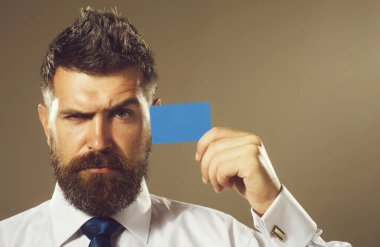 Çekici bir iş adamının portresi ve boş bir model kartı. Boş kartvizit ya da banka kartı gösteren ciddi sakallı bir adam. E-bankacılık, e-ticaret ve para transferi için kredi kartı olan yakışıklı bir erkek.