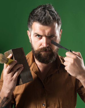 Düz jilet, tahta kutu ve tıraş fırçasıyla şık gömlekli sakallı adamın yakın plan portresi. Berber dükkanı servisi. Profesyonel berber seni tıraş etmeye hazır. Berber dükkanı ekipmanlı kuaför.