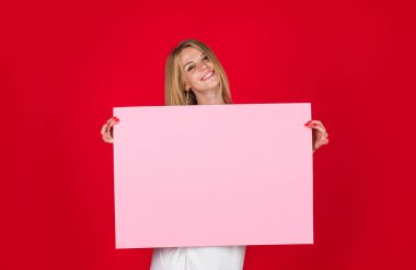 Gülümseyen kadın mesaj için fotokopi alanı olan boş ilan panosu gösteriyor. Pankart panosu tanıtımı. Boş reklam afişi olan güzel bir kız. Ürün reklamları ve indirim ve satış duyuruları