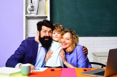 Okuldaki ilk günüm. Gülümseyen çocuk okulda öğretmenlere sarılıyor. Çocuk eğitimi, özel ders ve öğrenme. İlkokul öğrencisi çocuk sınıftaki en sevdiği öğretmenleri kucaklıyor.