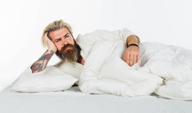 İyi sabahlar. Yatakta hayalperest bir adam uyanıyor ve evde tembelce hafta sonunun tadını çıkarıyor. Yatakta yatan yakışıklı sakallı adam sabah uyanır. Pijamalı çekici adam iyi bir uykudan sonra uyanıyor.