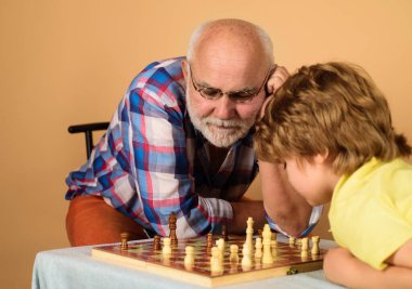 Büyükbabam ve torunum evde satranç oynuyorlar. Satranç yarışması. Son sınıf öğrencisi satranç oyununda bir sonraki hamleyi düşünüyor. Dedem çocuklara satranç öğretiyor. Mantık ve stratejik düşüncenin gelişimi