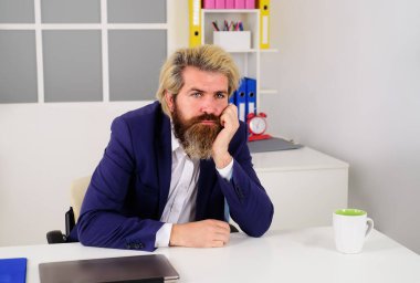 Ofisteki iş adamı. İş yerindeki masada oturan sakallı adamın portresi. Başarılı bir iş. Ciddi ciddi düşünceli iş adamı, mali yatırım kararları hakkında düşünen iş uzmanı