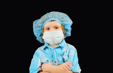 Enfeksiyon konsepti. Tıbbi maskeli küçük bir çocuğun portresi. Tek kullanımlık maskeli çocuk. Koruyucu maskeli hasta bir çocuk. Yüz maskesi virüse, salgına, gribe ve hava kirliliğine karşı. Hastalığı önleme