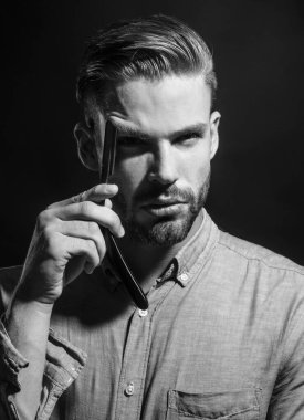 Profesyonel berber aleti. Bıyıklı adamlar. Klasik usturalı şık gömlekli yakışıklı bir adam. Tıraşsız bir adam tıraş bıçağıyla sakalını tıraş etmeye hazır. Berber dükkanı reklamı. Siyah ve beyaz