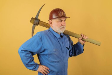 Sert şapkalı, kazmalı, ciddi bir duvarcı. Sakallı işçi tulumlu ve kazmalı kasklı. Zanaatkar, müteahhit ya da üniformalı madenci ve balta ile çalışan koruyucu miğfer.