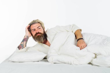 Günaydın ve uyan. Bornozlu sakallı adam yatakta uyuyor. Sabah uyanması. Millet, uyku zamanı ve dinlenme konsepti. Adam evde yatıyor. İyi sabahlar. Yakışıklı adam yatak odasında uyanıyor.