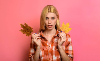 Sonbahar kadını. Sonbahar yapraklı, şık ekose gömlekli ciddi bir kız. Sonbahar havası. Sarı akçaağaç yapraklı gündelik giysiler içindeki sonbahar kadını. Akçaağaç yaprağı desenli tişörtlü modacı kadın.