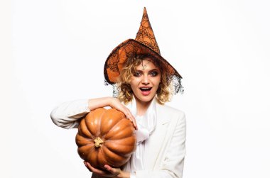 Cadı şapkalı, balkabaklı gülümseyen kız. Balkabağı fenerli cadılar bayramı cadısı kadın. Cadılar Bayramı partisi kızı. Cadılar Bayramı 'nda sihirli balkabağı olan mutlu genç bir kadın. Şeker mi şaka mı? Cadılar Bayramı indirimi ve alışveriş