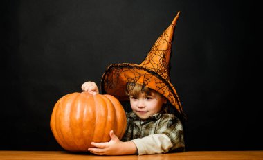 Mutlu Cadılar Bayramı. Cadılar Bayramı balkabaklı şirin çocuk. Elinde balkabağı feneri olan gülümseyen çocuk. Şeker mi şaka mı? Cadılar Bayramı. Sihirli balkabaklı küçük çocuk. Cadılar Bayramı partisi için hazırlık