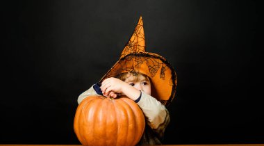 Balkabağı kabaklı şirin Cadılar Bayramı çocuğu. Cadılar Bayramı balkabaklı küçük çocuk başka tarafa bakıyor. Şeker mi şaka mı? Cadılar Bayramı kutlaması. Cadılar Bayramı alışverişi, satış ve indirim.